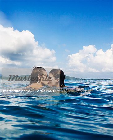 A couple kissing in the water, Thailand.