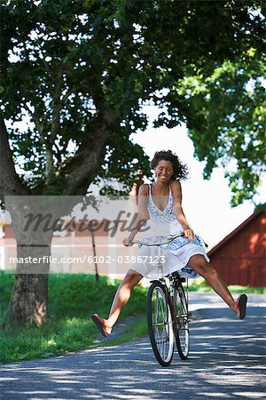 A woman riding a bike in the Swedish countryside.