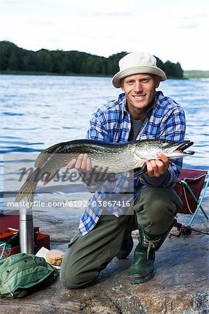 A man holding a pike, Sweden.