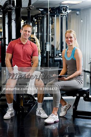A man and a woman weight training at a gym, Sweden.