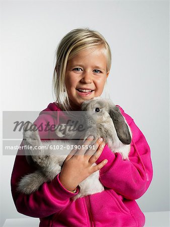 Portrait of a girl with a rabbit in her arms.