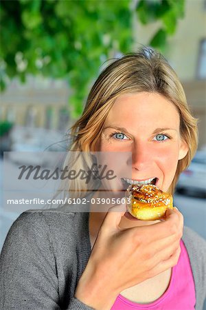 Woman eating a bun.