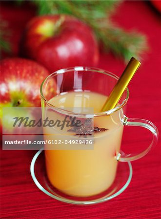 Glass of apple juice with two apples