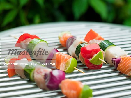 Fish and vegetable skewer in barbecue grill, close-up