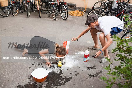 Kids playing with food on sidewalk