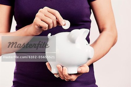 A woman holding a savings box