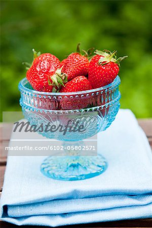 Strawberries in bowl on wooden table
