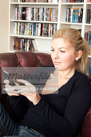 Woman sitting in sofa and text messaging