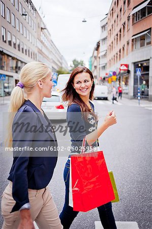 Two women with shopping bags in street