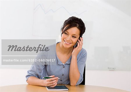 Portrait of smiling businesswoman talking via cell phone