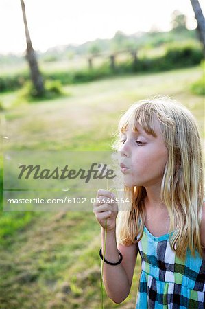 Girl blowing dandelion