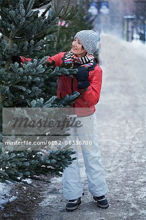 Smiling woman choosing Christmas tree