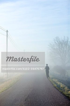 One person running on a hazy road, Sweden.