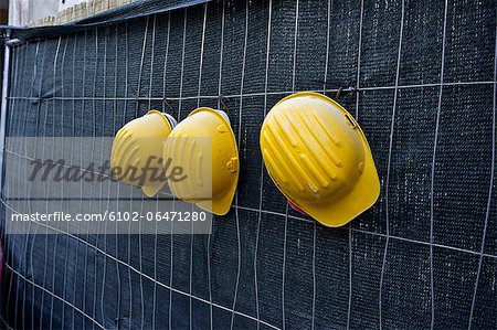 Three yellow hardhats hanging