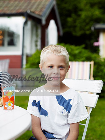 Portrait of boy sitting at outdoor table