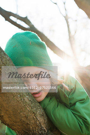 Girl on tree looking at camera, Stockholm, Sweden