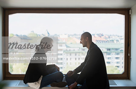 Smiling couple against window, Sweden