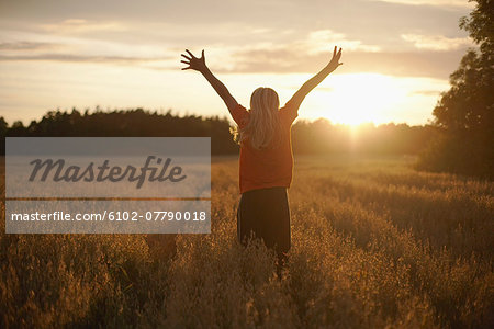 Boy standing on field at dusk