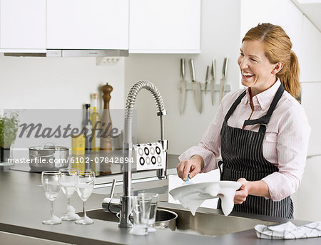 Smiling woman washing dishes