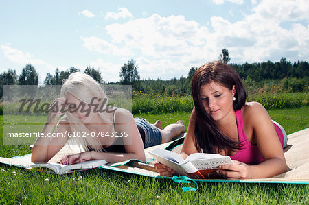 Young women reading books outdoor