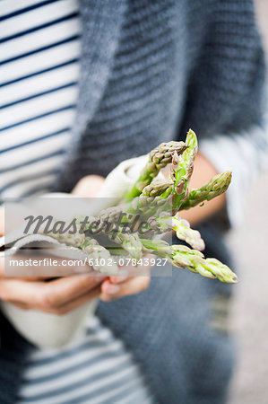 Hands holding green asparagus