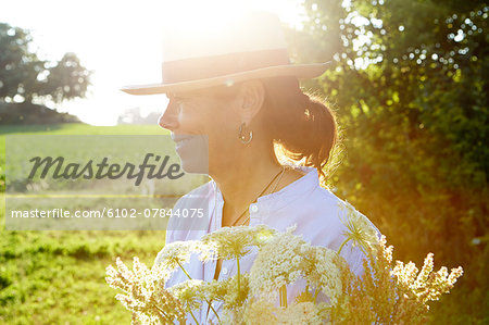 Mature woman wearing sun hat looking away