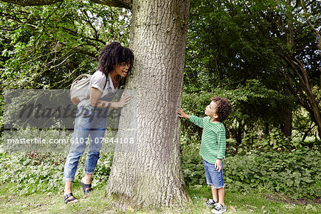 Mother with son playing near tree