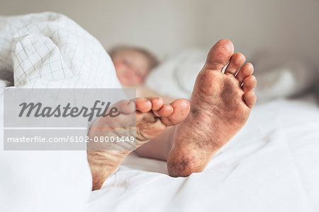 Childs dirty feet in bed