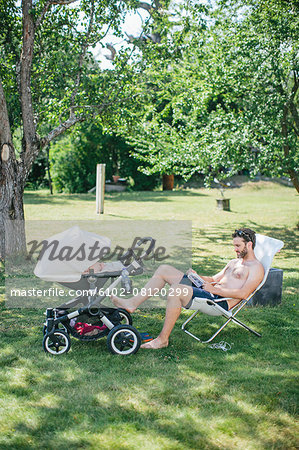 Father in garden with child in buggy