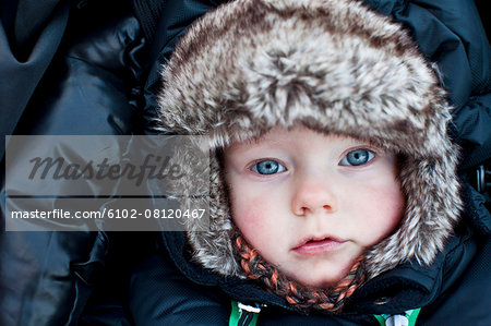 Portrait of baby boy wearing fur hat