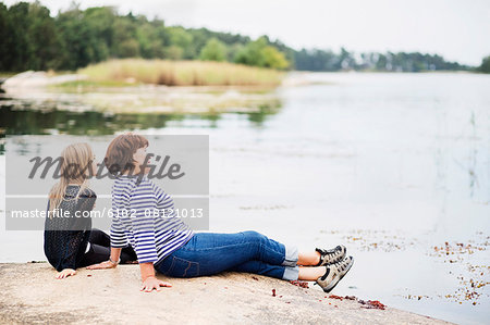 Mother with daughter relaxing at lake
