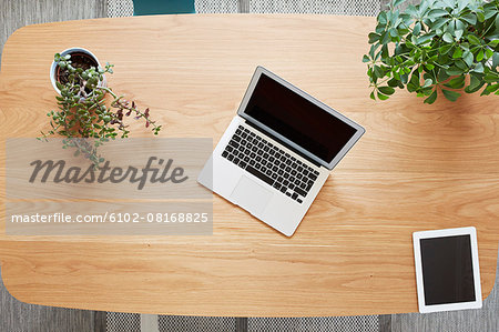 Laptop and tablet on wooden desk