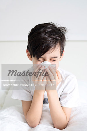 Boy blowing his nose