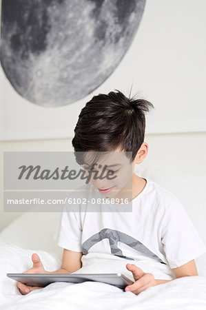 Boy in bed with digital tablet