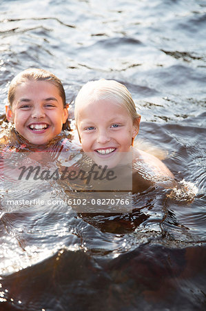 Brother and sister swimming in water