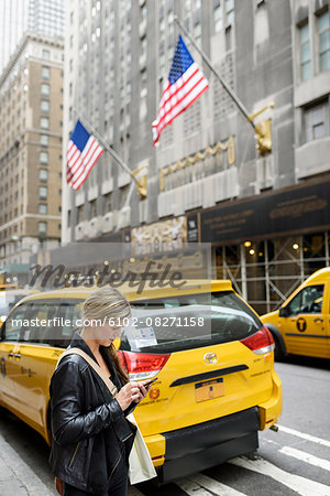 Woman using cell phone on street