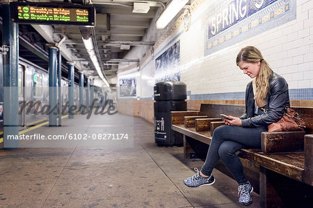 Woman using cell phone on train station. New York City, USA Woman using cell phone on train station. New York City, USA