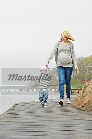 Woman with son walking on jetty