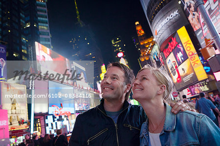 Couple at Times Square at night, New York City, USA
