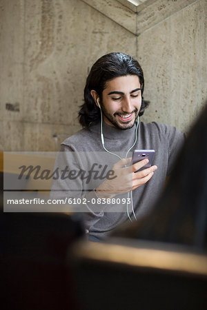 Young man in cafe listening music