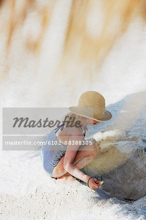 Girl playing with sand on beach