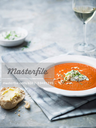 Soup on table with bread roll and wine