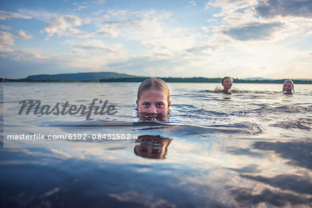 Father and children swimming in lake