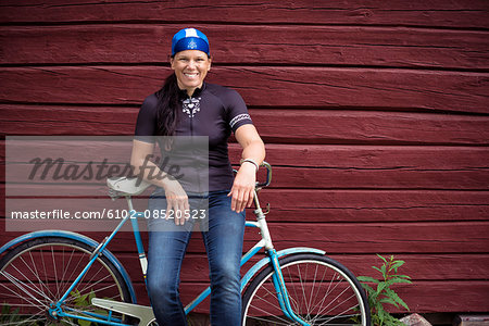 Portrait of mid-adult woman sitting on bicycle