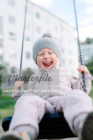 Boy having fun on swing in playground