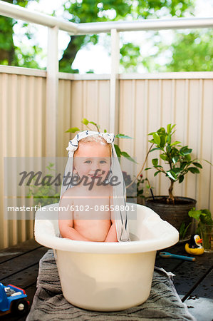 A young boy bathing in a tub