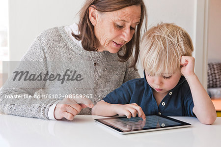 Grandmother with grandson using digital tablet
