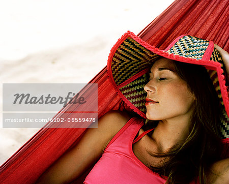 A Scandinavian woman resting in a hammock, Thailand.