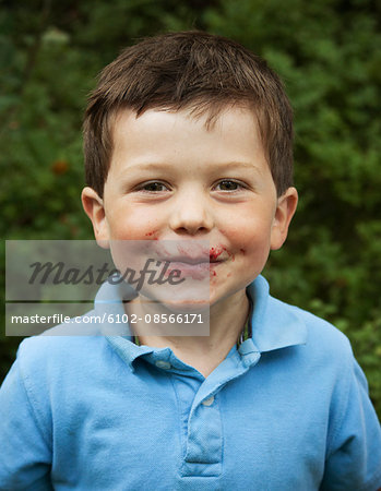 Boy with blueberry juice on face, close-up, portrait