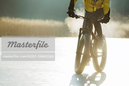 Man cycling on a frozen lake